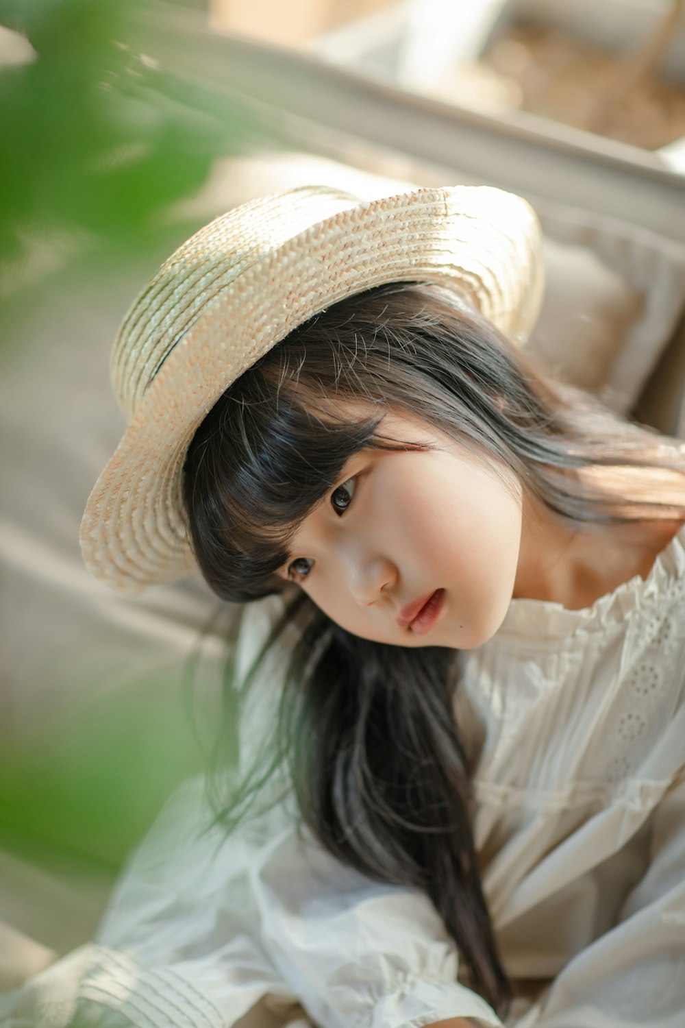 a young girl wearing a white dress and a straw hat
