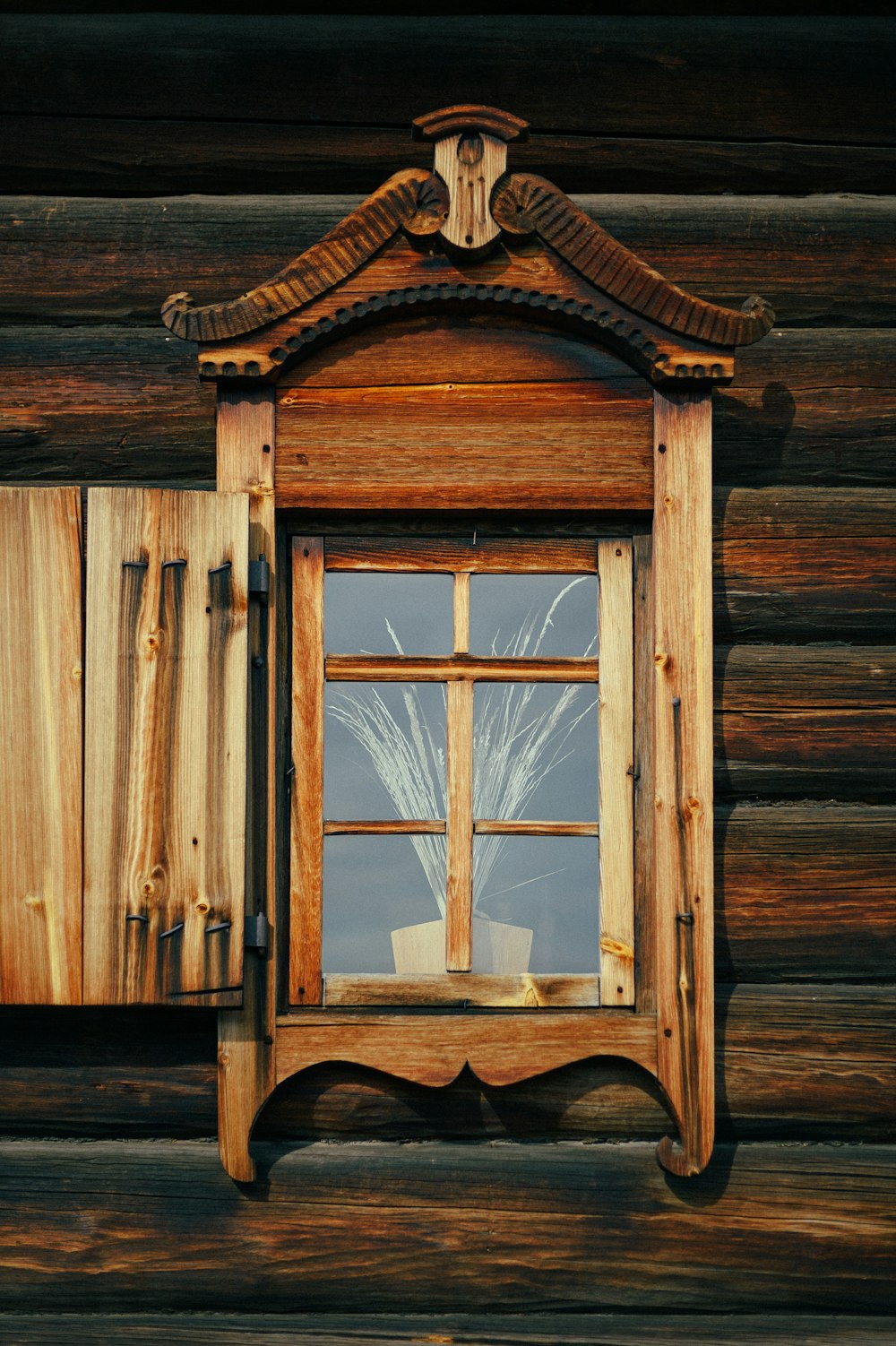 a window with a wooden frame and a tree in the window