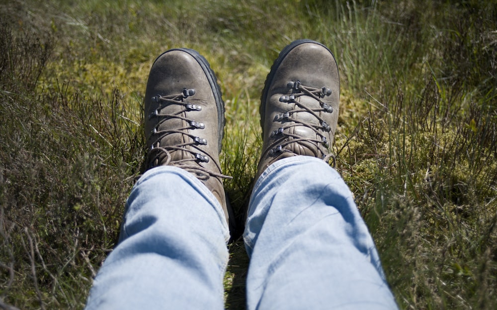a person wearing hiking boots standing in a field