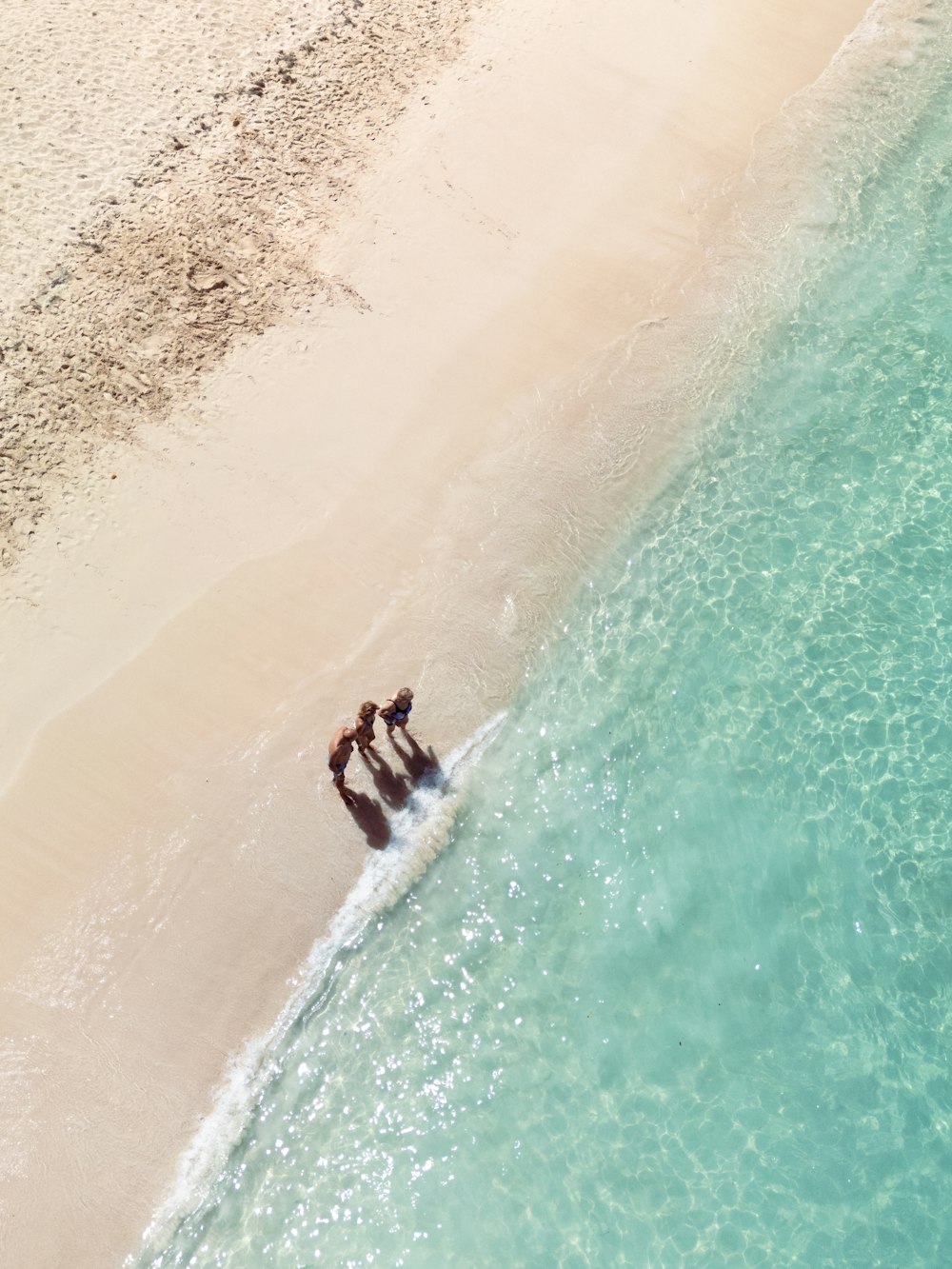 a couple of people riding a wave on top of a surfboard