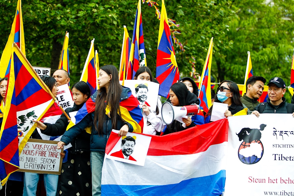 a large group of people holding flags and signs