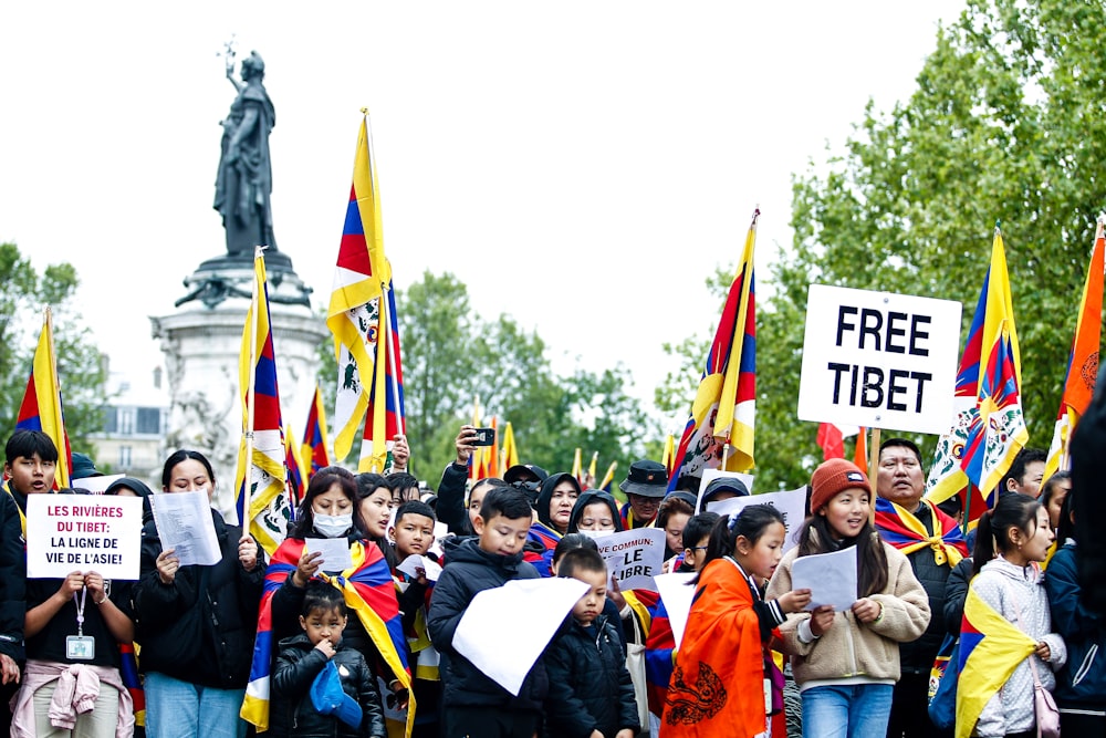 a large group of people holding flags and signs