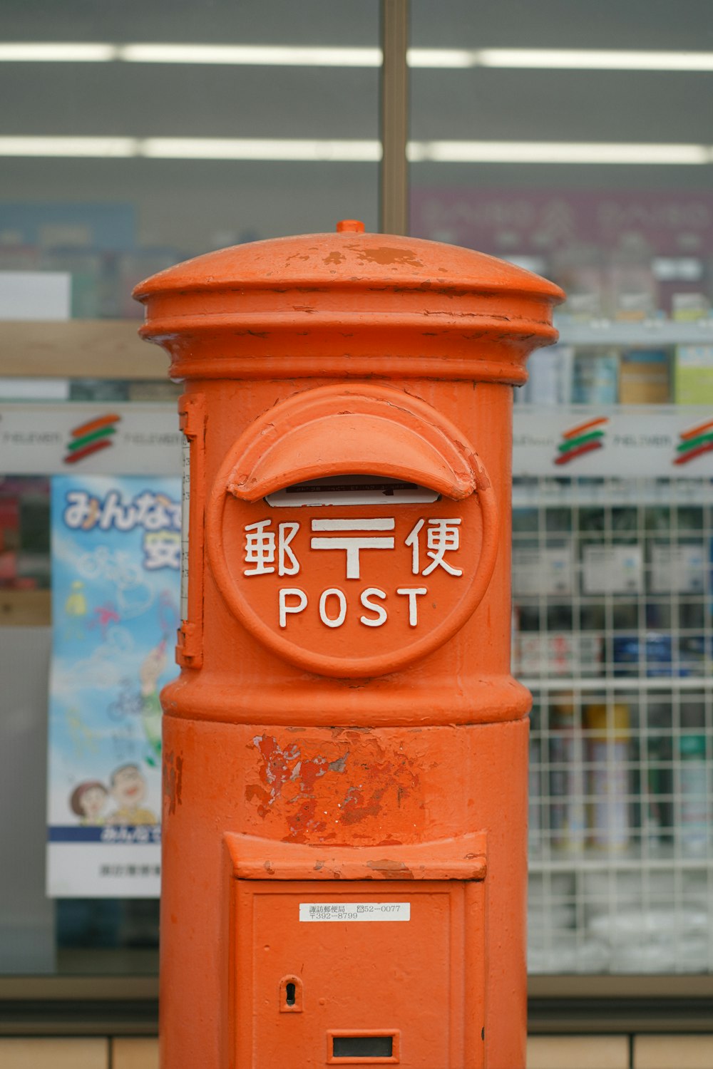 an orange post box sitting in front of a store