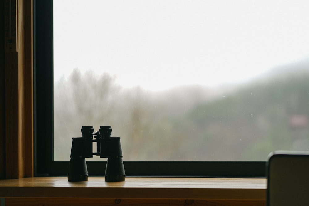 a pair of binoculars sitting on top of a window sill