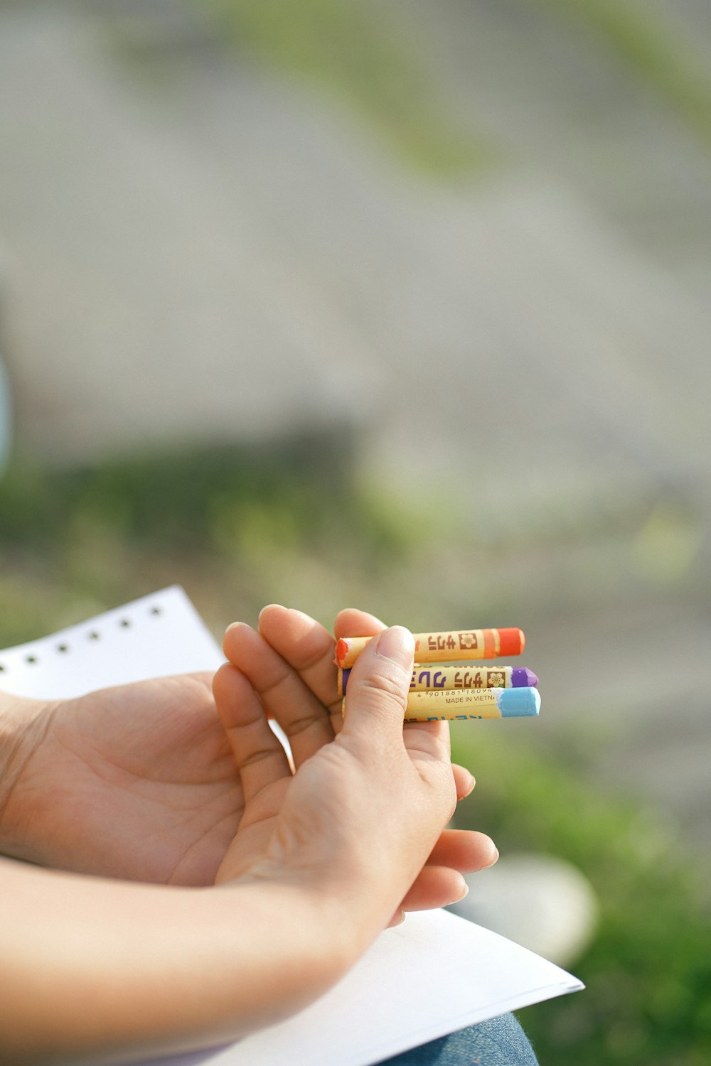 a person holding a pencil and writing on a piece of paper