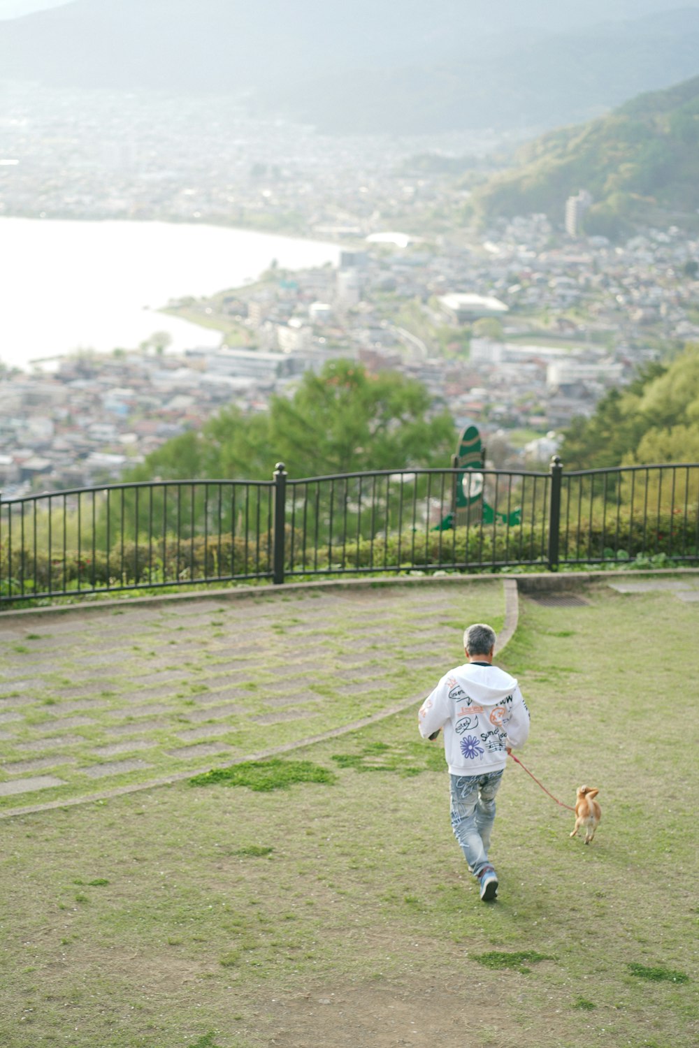 a man walking a dog on a leash in a park