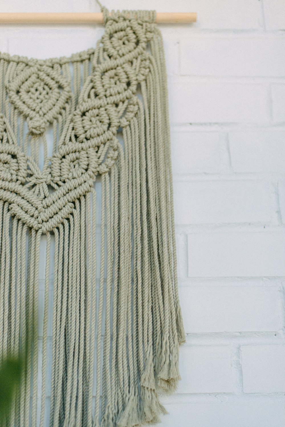 a macrame wall hanging on a brick wall