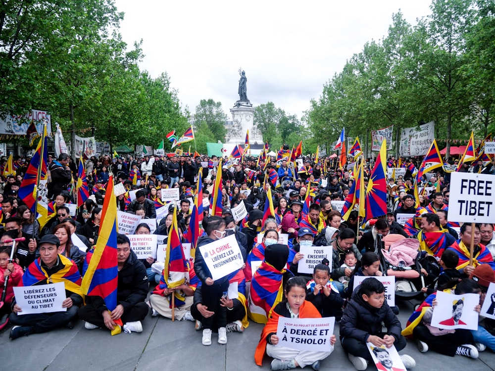 a large group of people holding flags and signs