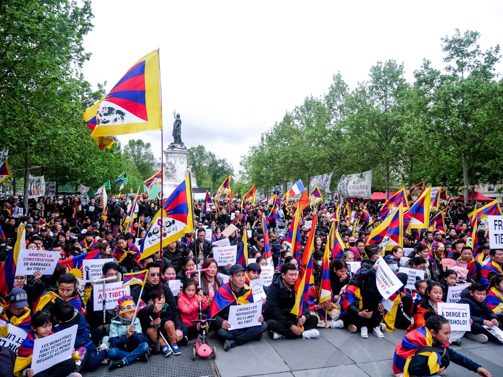 a large group of people holding flags and signs