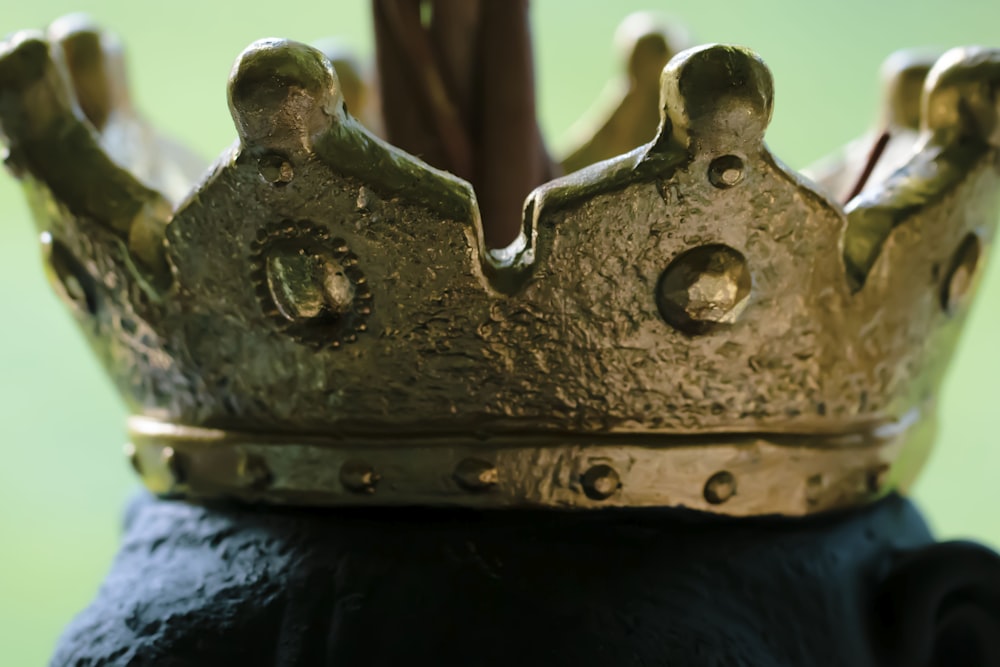 a close up of a gold crown on top of a black object
