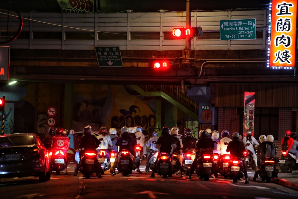 a group of people riding motorcycles down a street