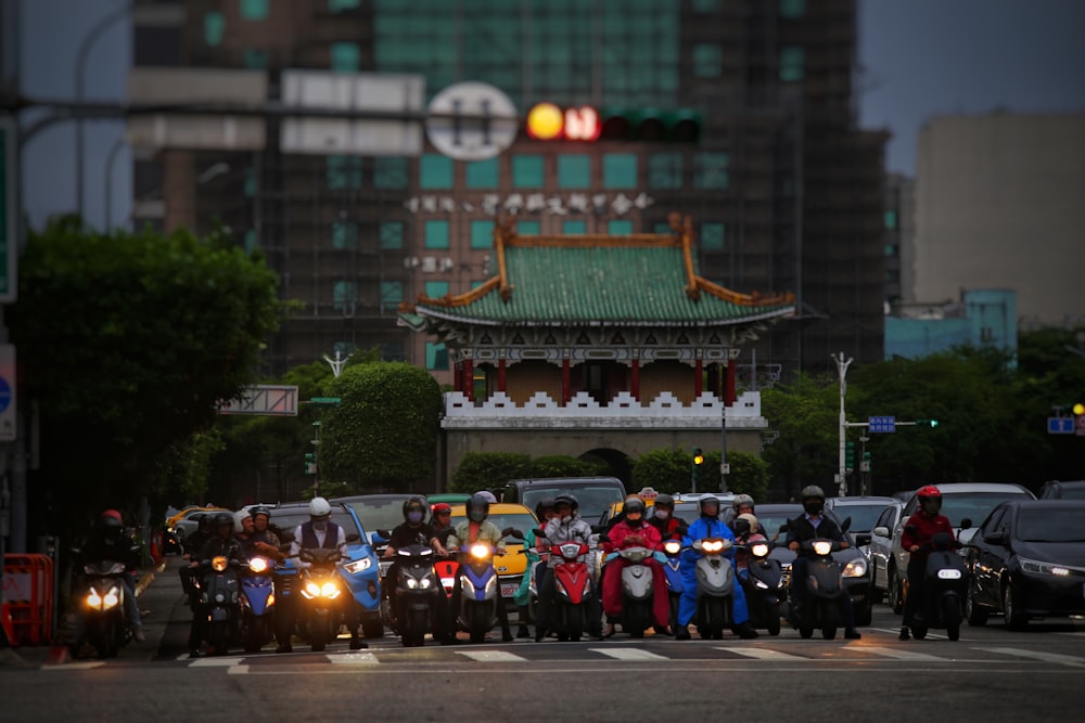 a group of people riding motorcycles down a street