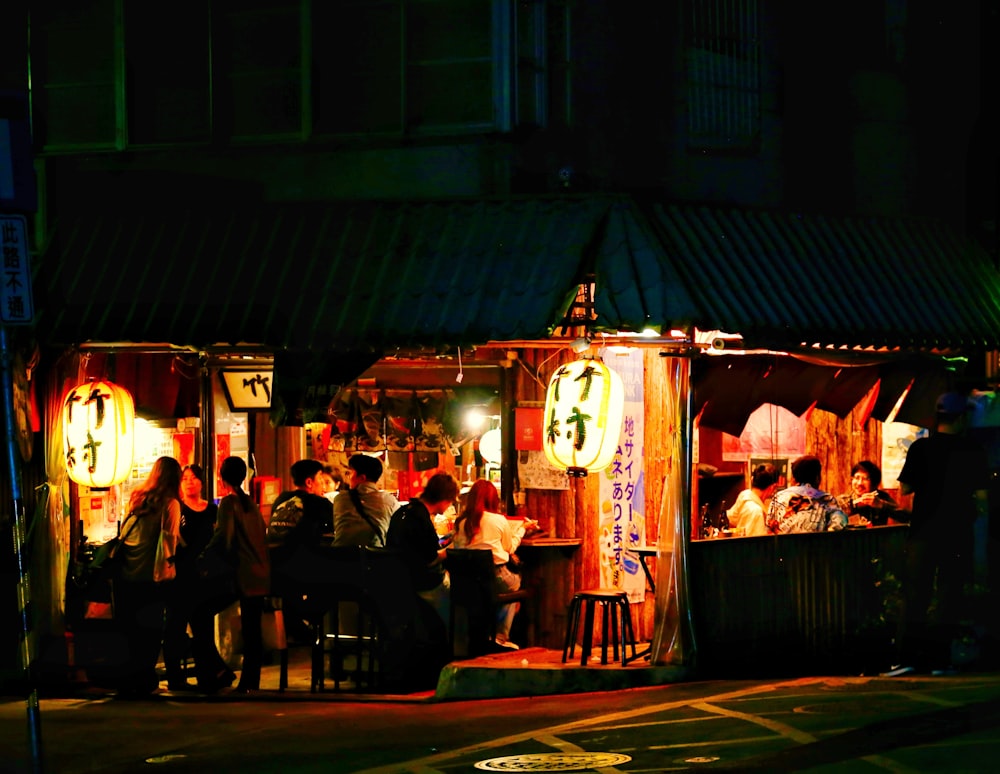 a group of people standing outside of a building at night