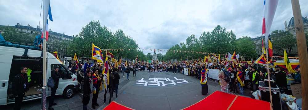 a group of people standing around a street holding flags