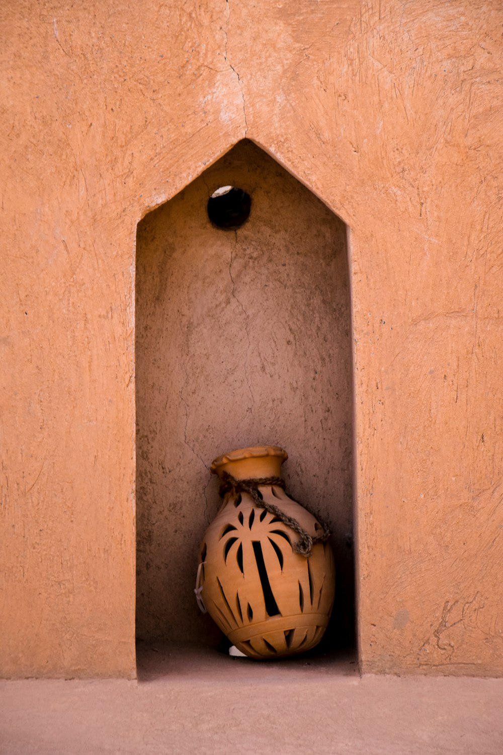 a vase sitting in a corner of a building