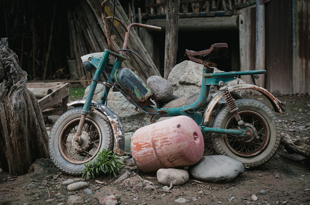 an old motorcycle sitting on top of a pile of rocks