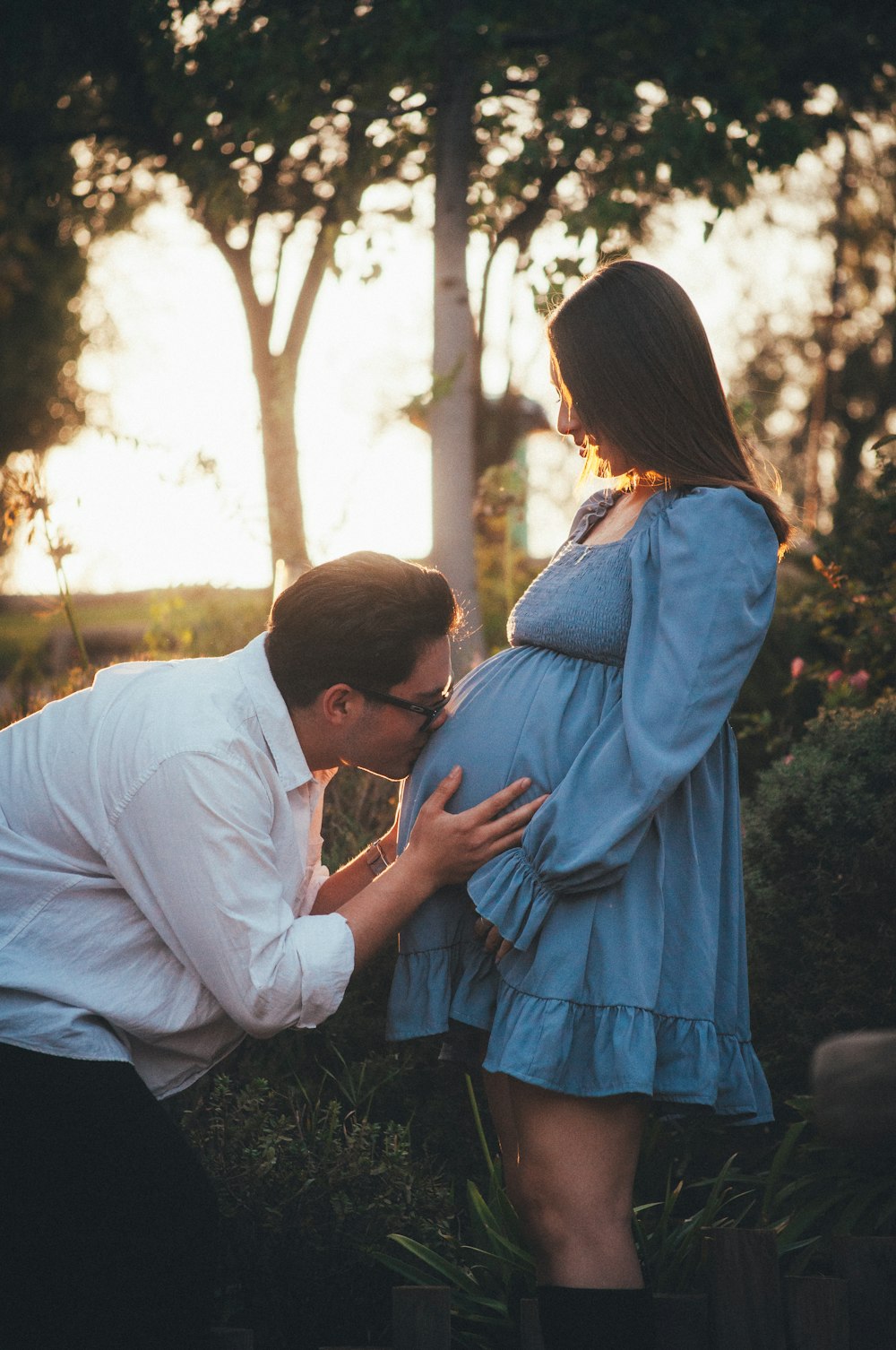 a pregnant woman is touching her husband's belly