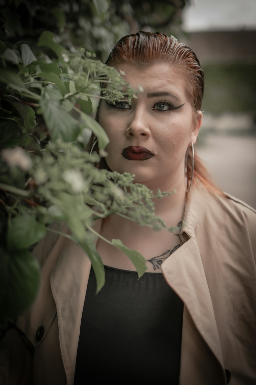 a woman with red hair wearing a tan jacket