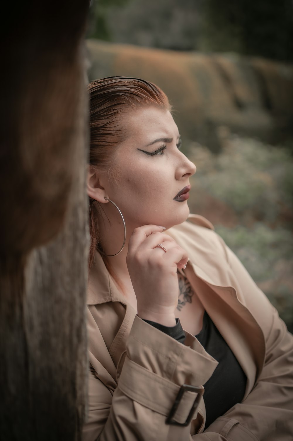 a woman leaning against a tree with her eyes closed