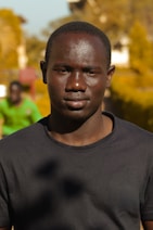 a man in a black shirt is looking at the camera