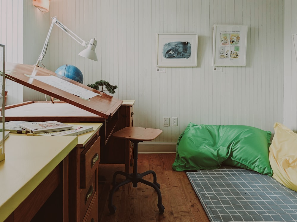 a room with a bed, desk and a lamp