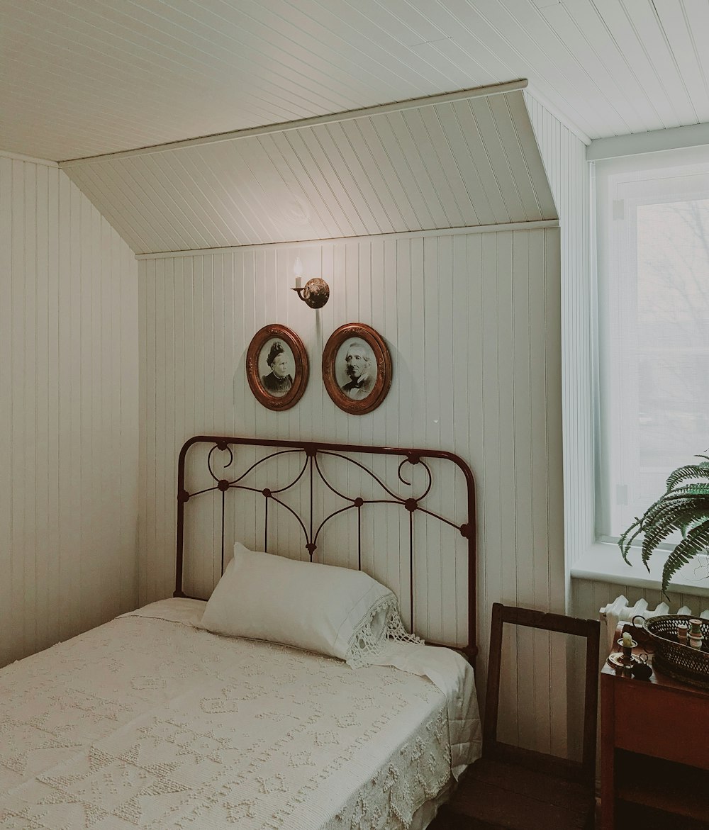 a bedroom with a bed and two pictures on the wall