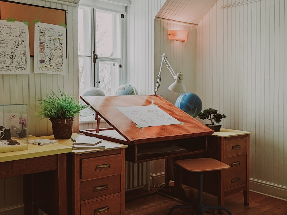 a desk with a chair and a lamp in a room