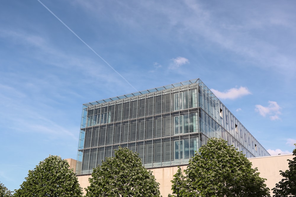 a large glass building with trees in front of it