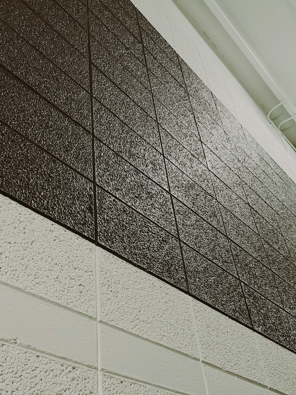 a black and white photo of a wall and a clock