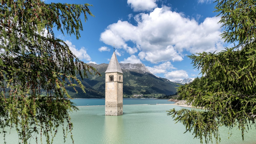 una torre de reloj sentada en medio de un lago