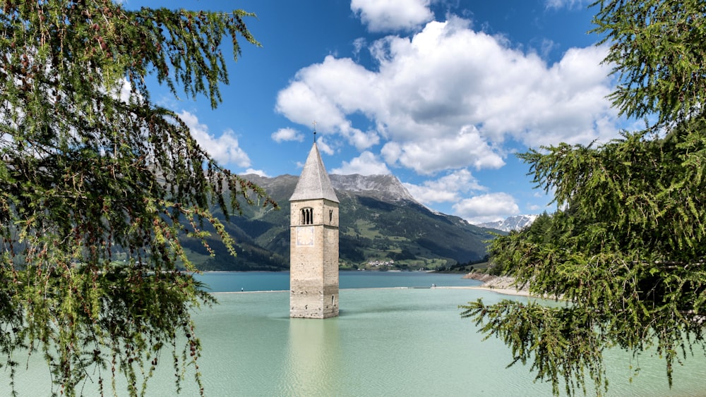 a clock tower sitting in the middle of a lake