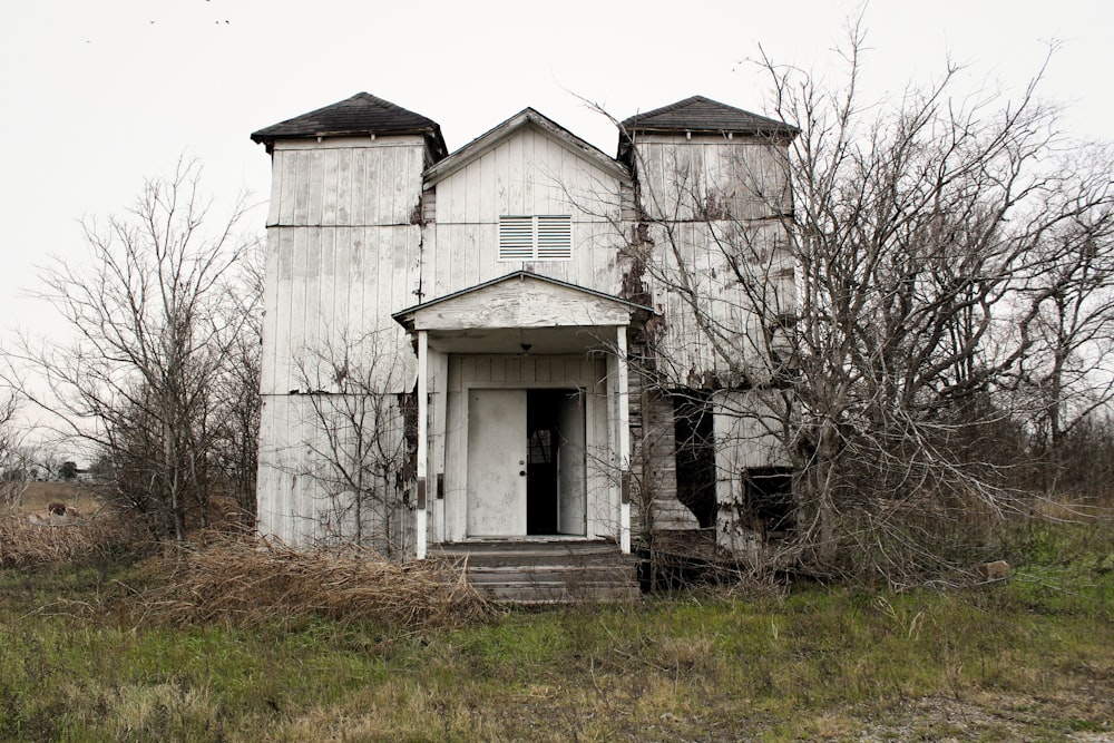 an old run down house in a field