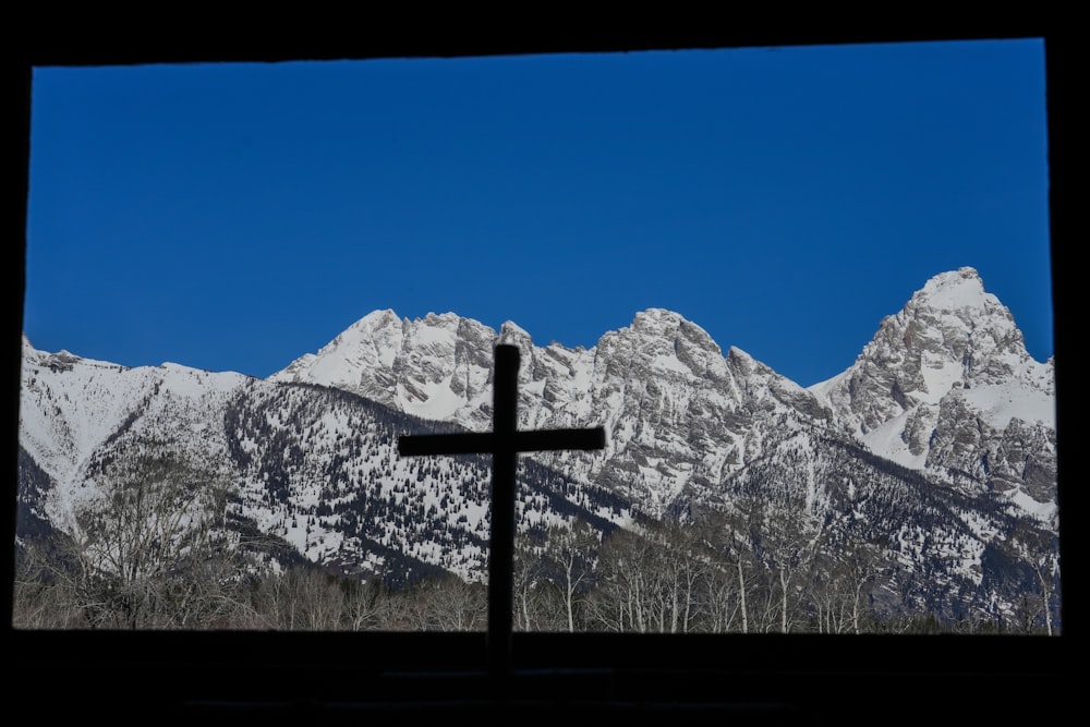 a cross in front of a mountain range