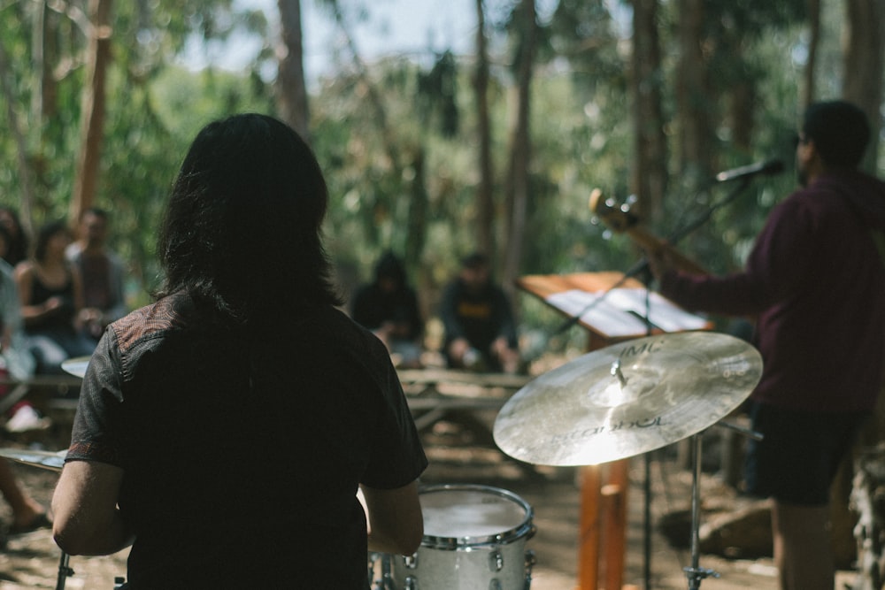 a group of people playing music in the woods