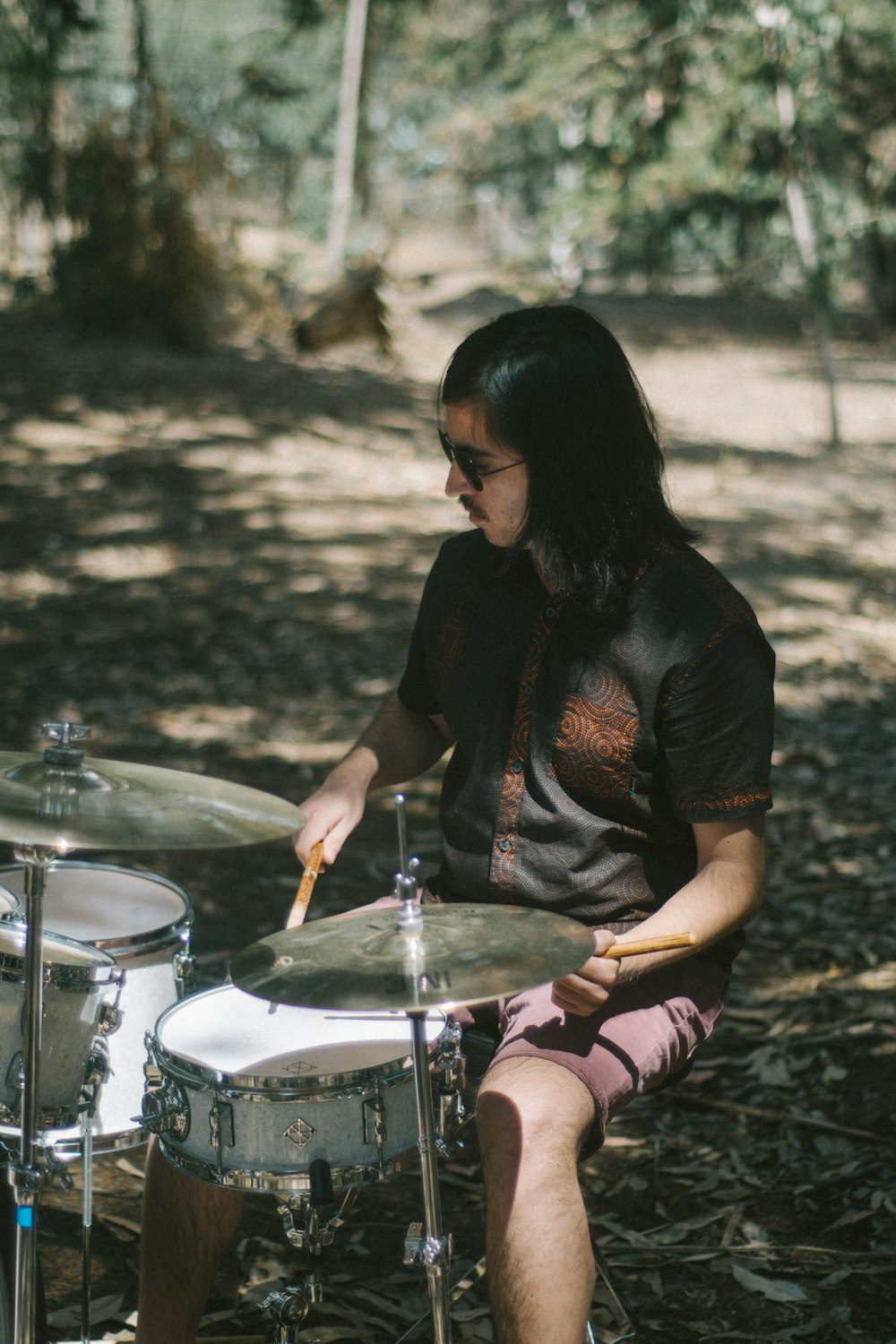 a man sitting on the ground playing drums