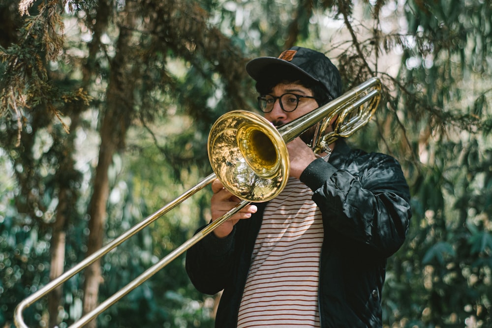 a man playing a trombone in a forest