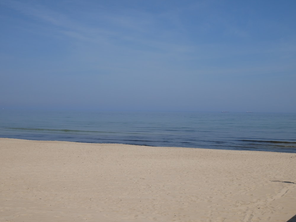 une personne marchant sur une plage avec une planche de surf