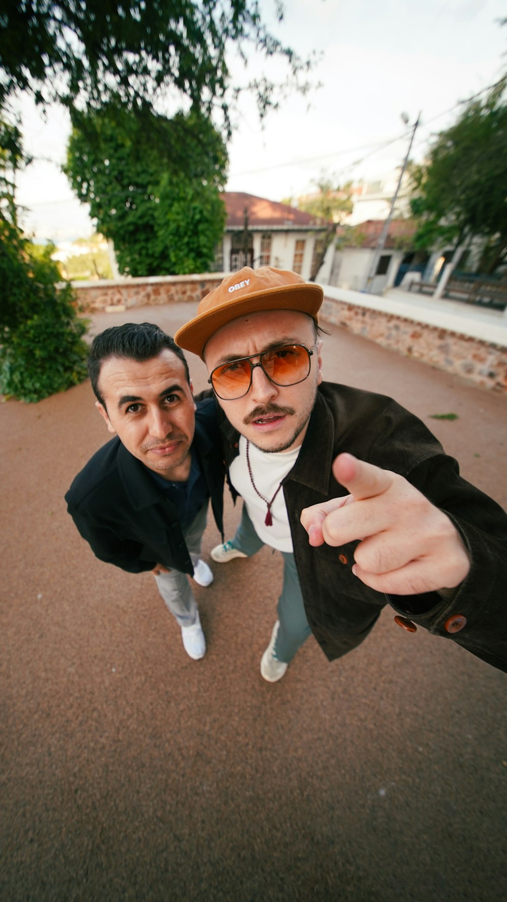 two men standing next to each other pointing at the camera