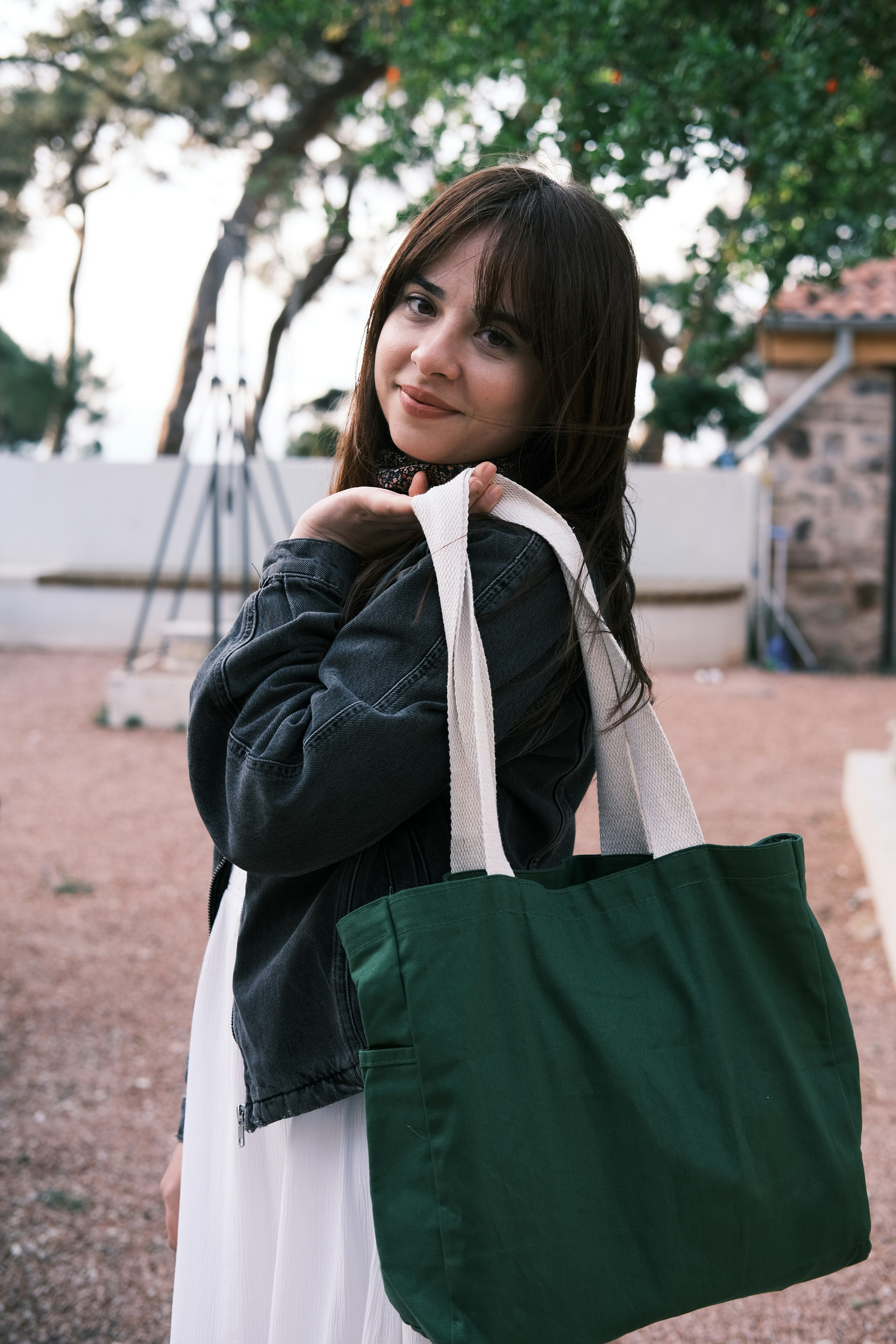 a woman is holding a green and white bag