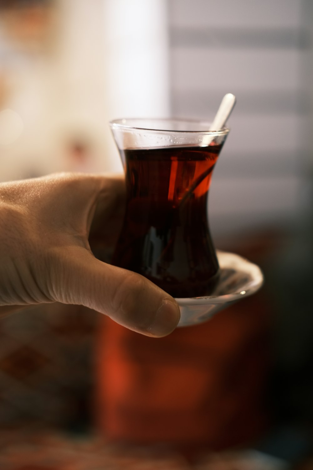 a person holding a cup of tea in their hand