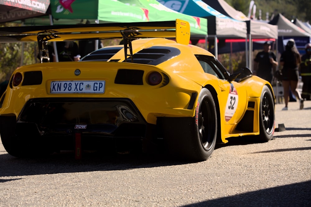 a yellow race car parked on the side of a road