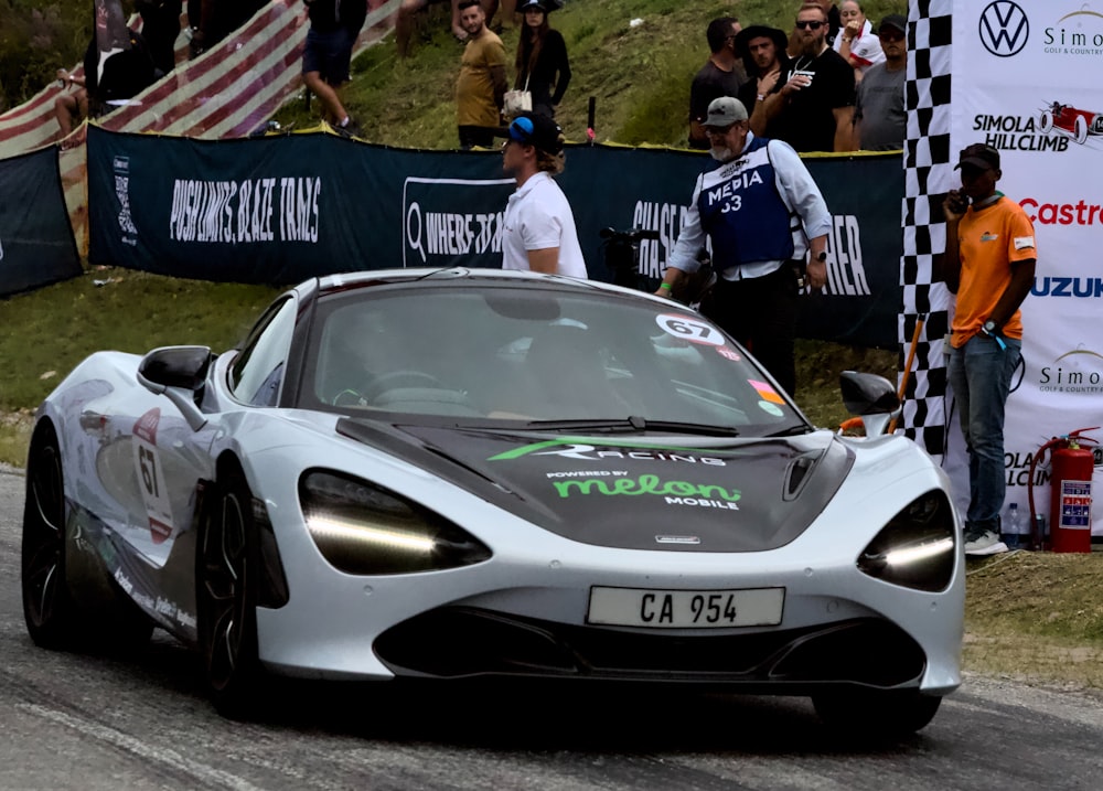 a white sports car driving down a race track