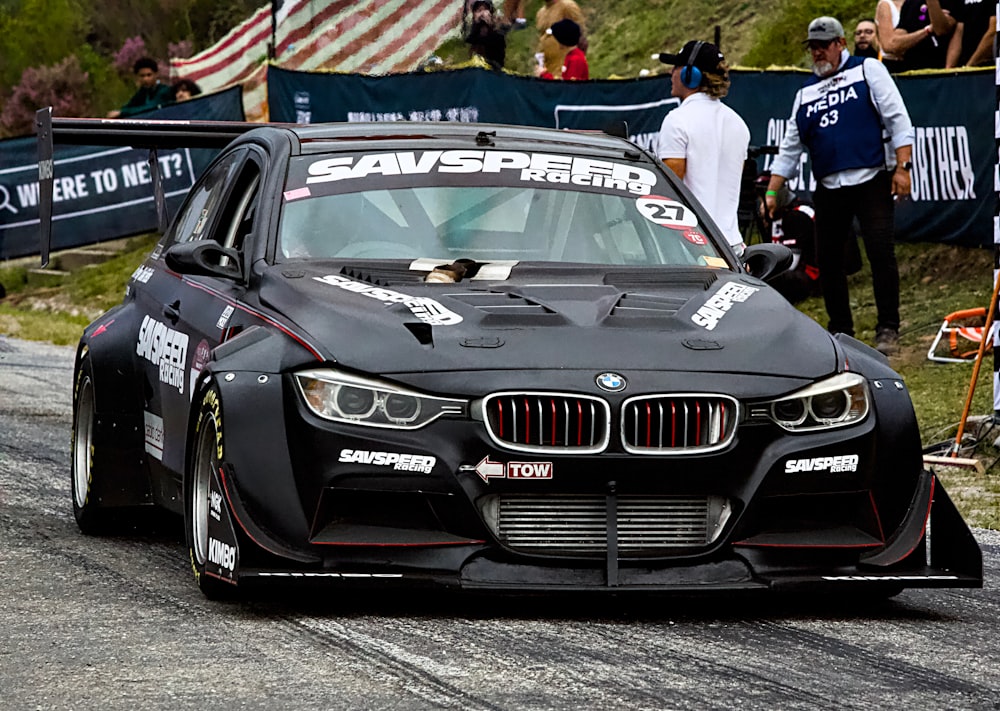 a black car driving down a race track