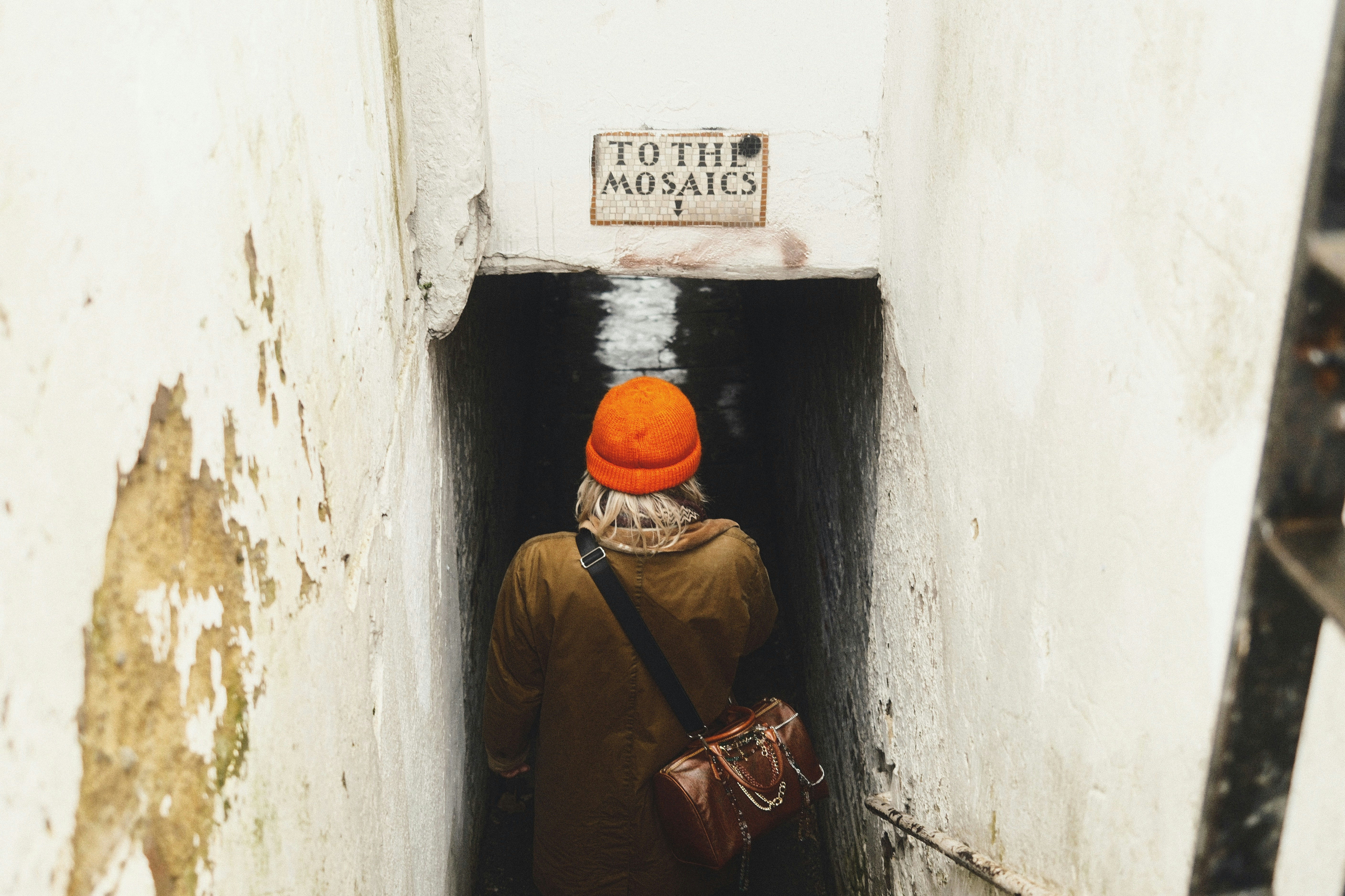 une personne avec un chapeau orange entrant dans un tunnel
