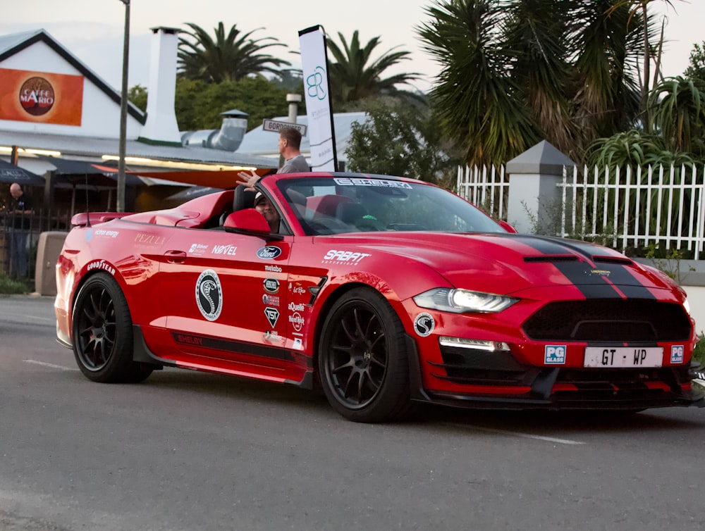 a red sports car driving down a street