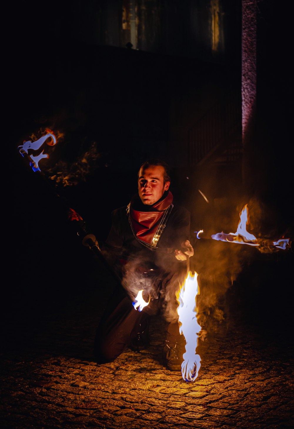 a man sitting on the ground holding a fire