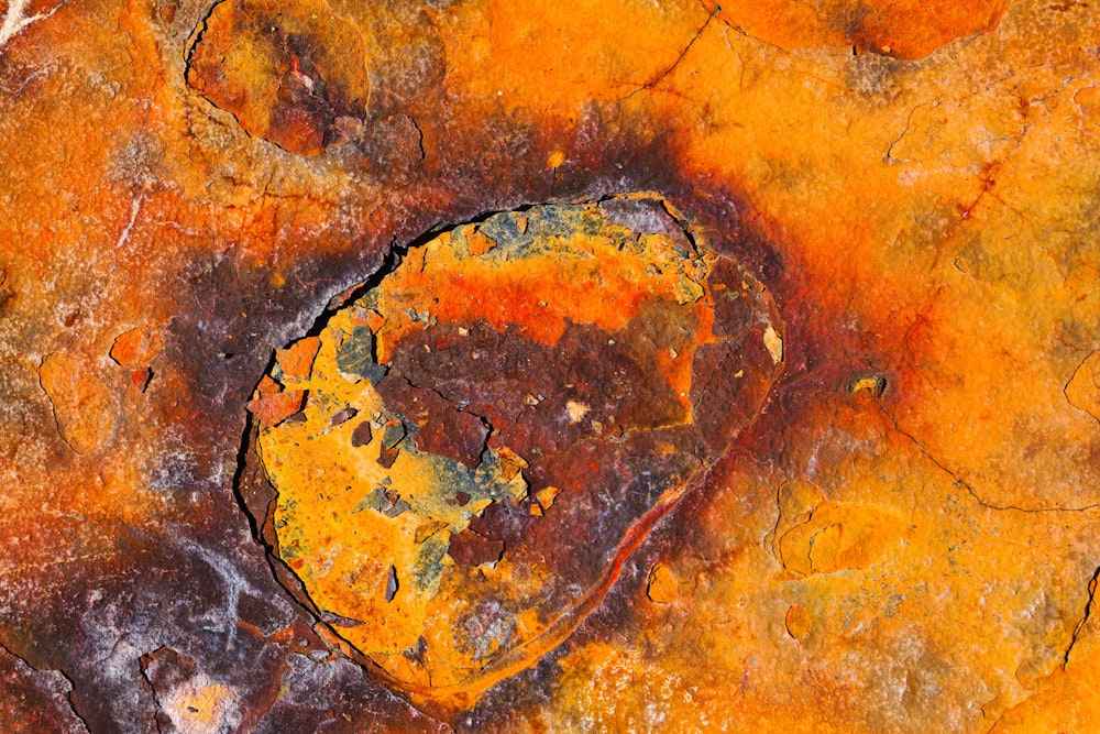 a close up of a rock with yellow and brown paint