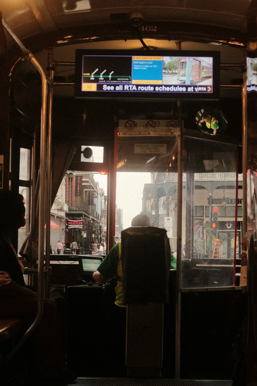 a person sitting in a bus with a tv above their head