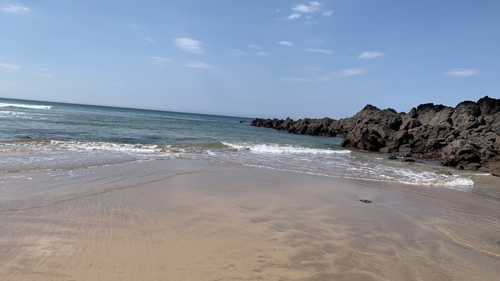 a sandy beach with waves coming in to shore