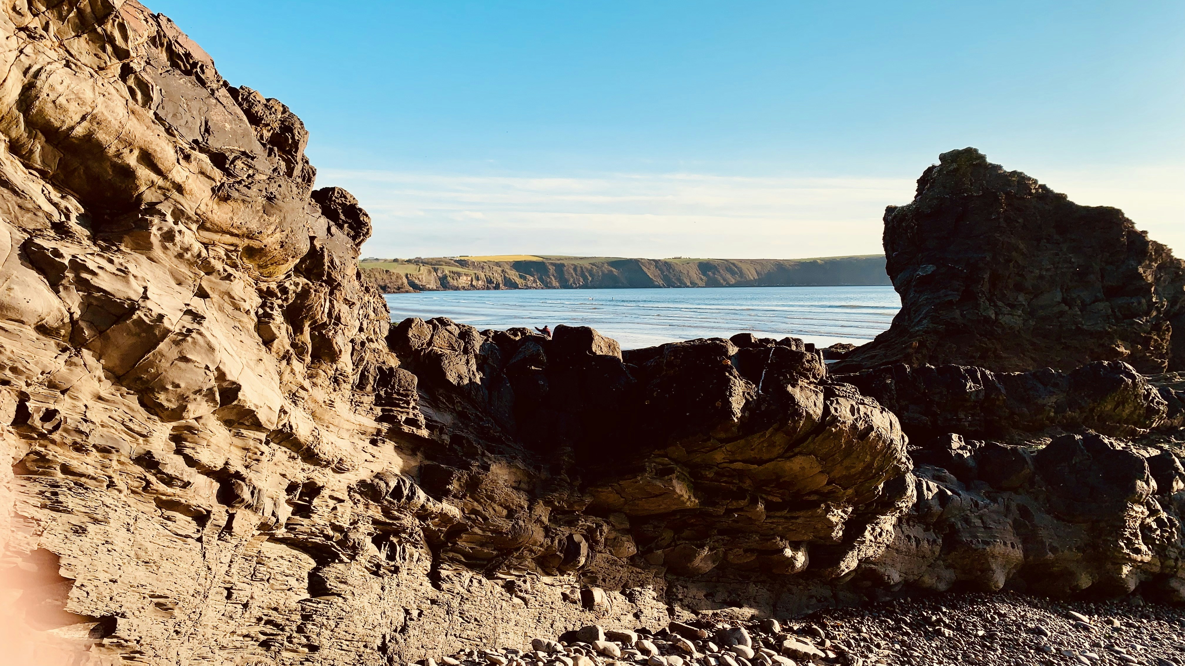 a rocky cliff with a body of water in the background